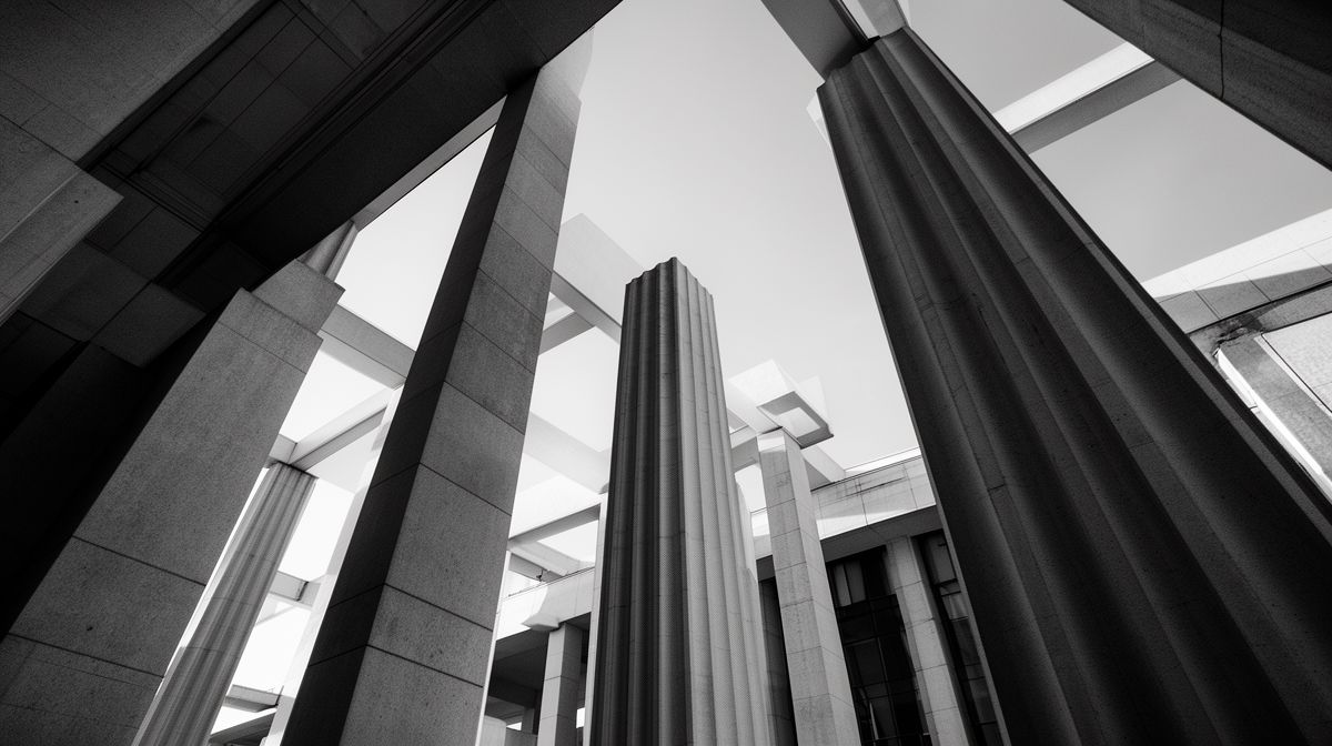 Colunas arquitetônicas em preto e branco, simbolizando a estrutura regulatória do sistema financeiro.